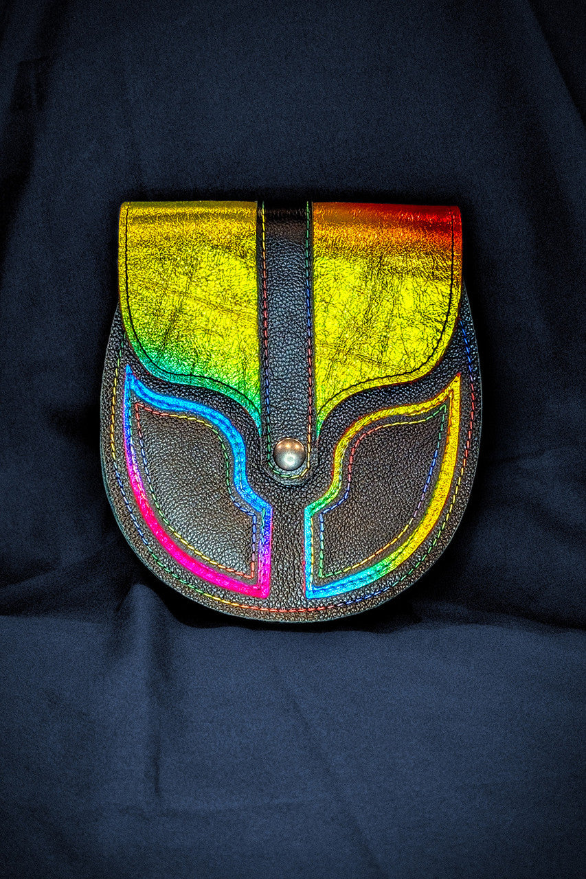 Black and metallic rainbow leather sporran to celebrate pride on a dark blue cloth background.