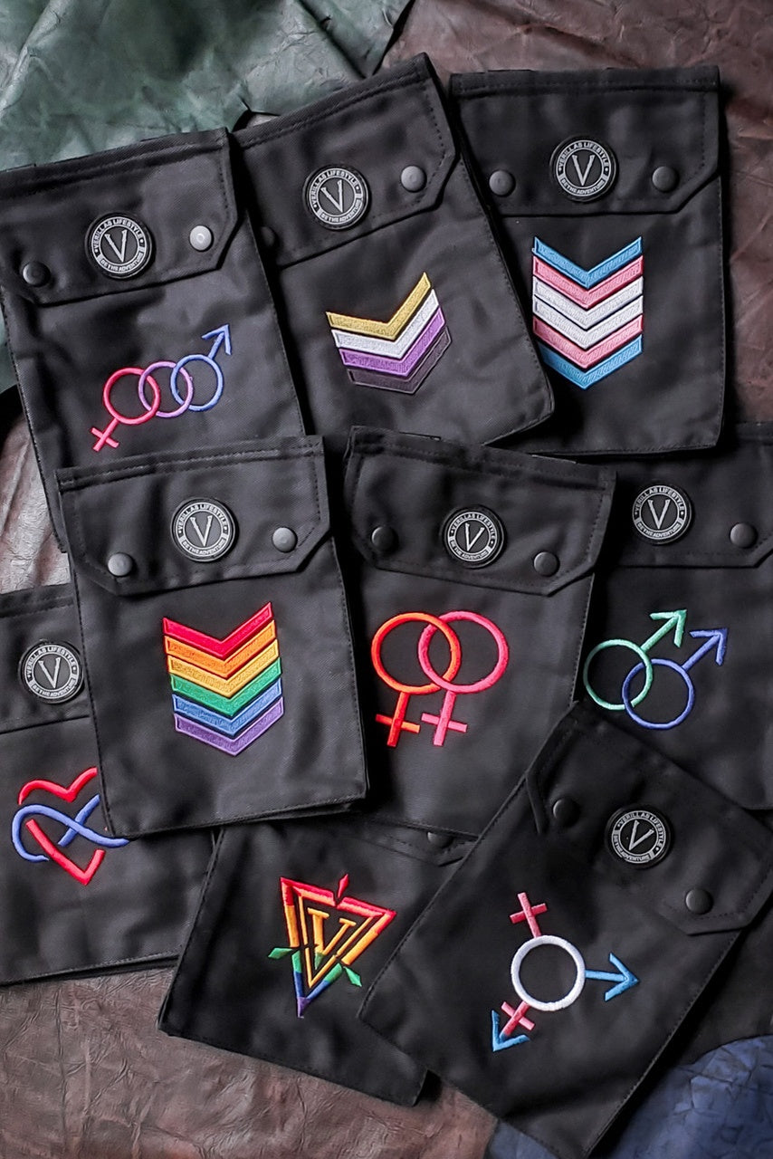 Black patches with various pride-themed symbols on a textured surface