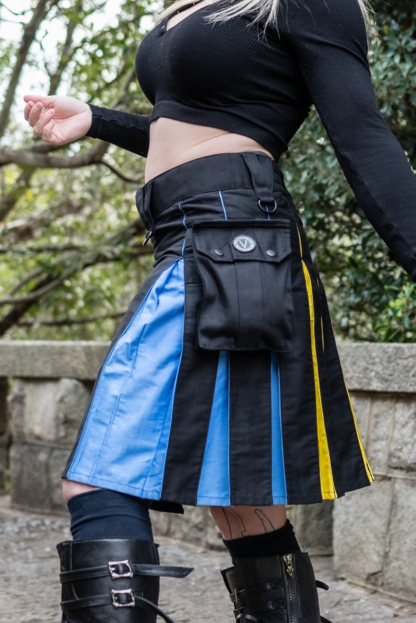 Person wearing a black and blue striped kilt with yellow accents outdoors.