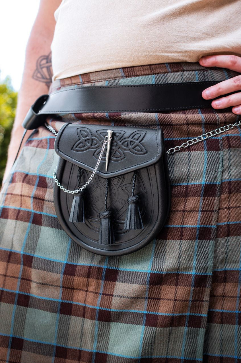 Person wearing a traditional Scottish kilt with a sporran and belt.