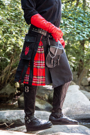 Person wearing a red and black outfit with a kilt in a natural setting