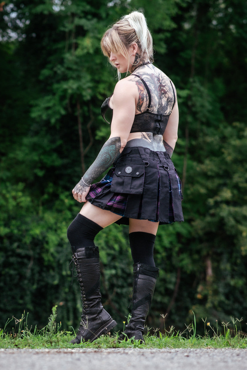 Left side view of a woman wearing a black mini kilt with purple and blue details and a side pocket.