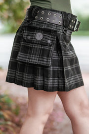 Black and grey plaid mini kilt with a belt worn by a person, blurred background