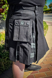 Person wearing a black and grey plaid kilt with a visible Versatta V logo on a side pocket.
