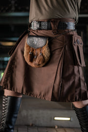 Brown kilt with a fur pouch and belt worn by a person, blurred background