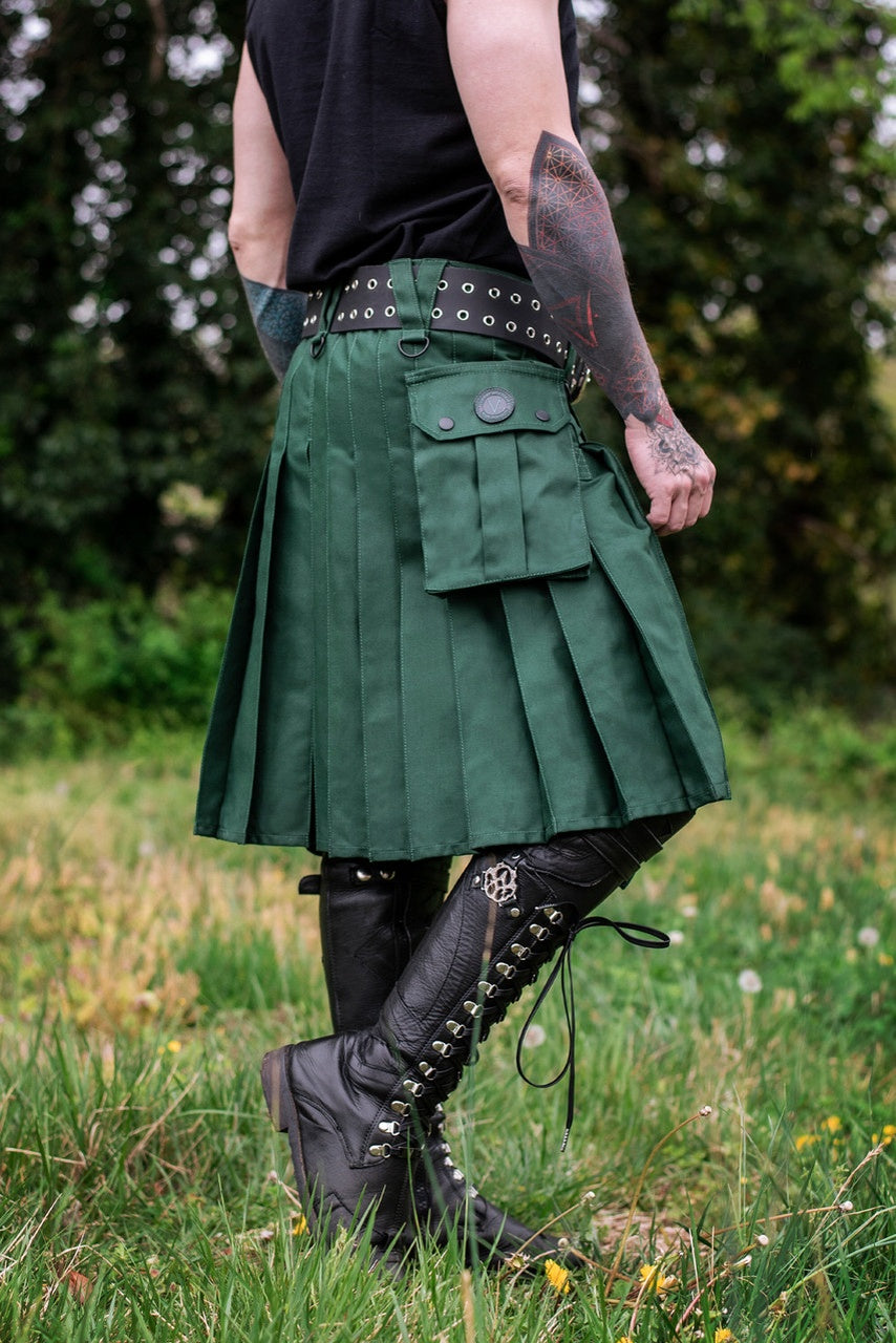 Person wearing a green kilt with black boots in a grassy outdoor setting