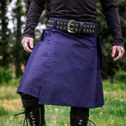 Person wearing a purple kilt with a belt in an outdoor setting