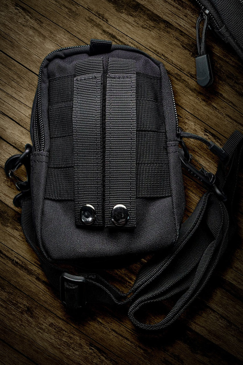 Black tactical pouch on a wooden surface