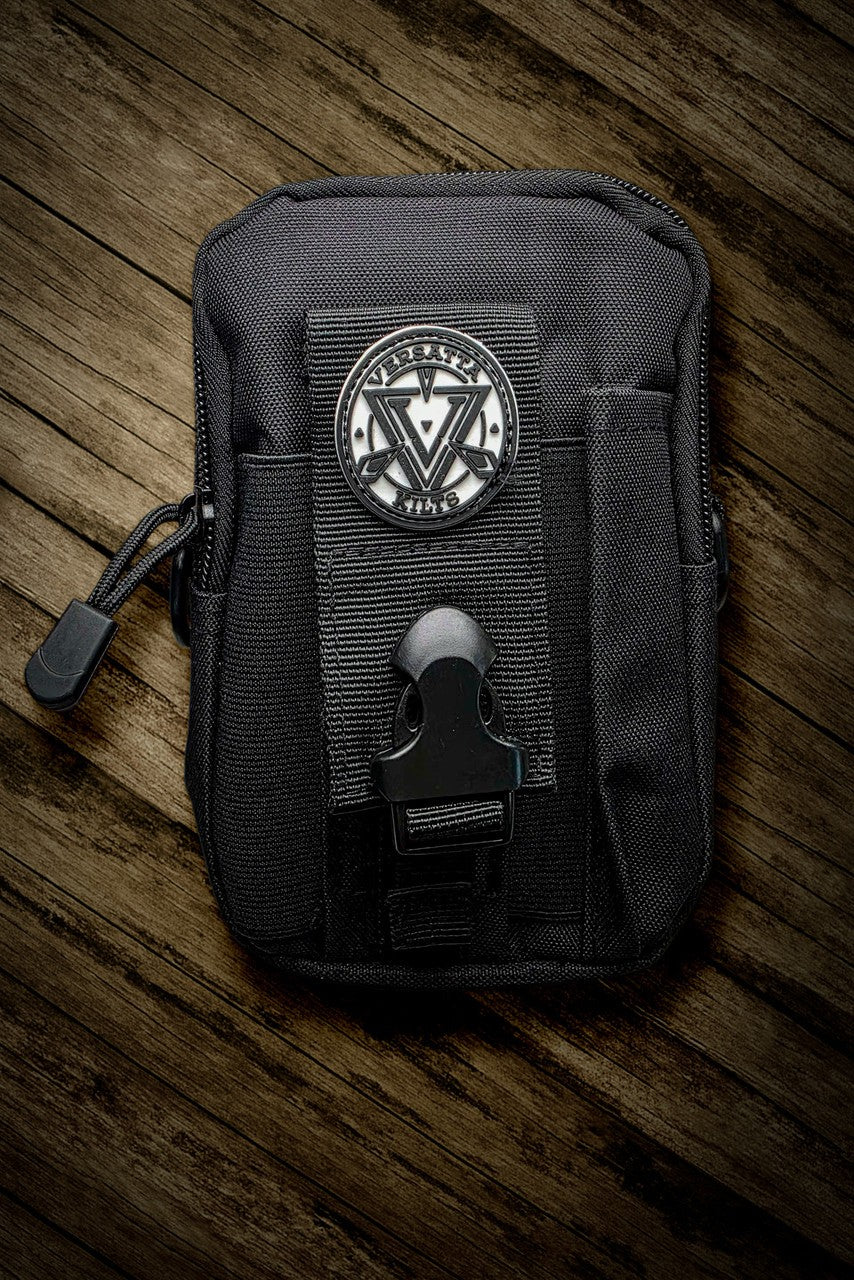 Black tactical pouch with a logo on a wooden surface