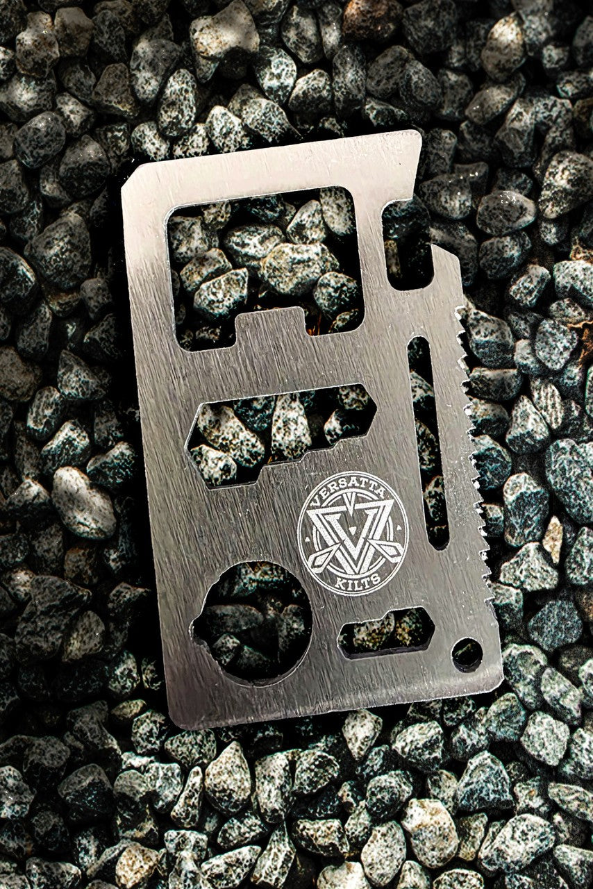 Metal multi tool on a gravel background with the Versatta Kilts logo
