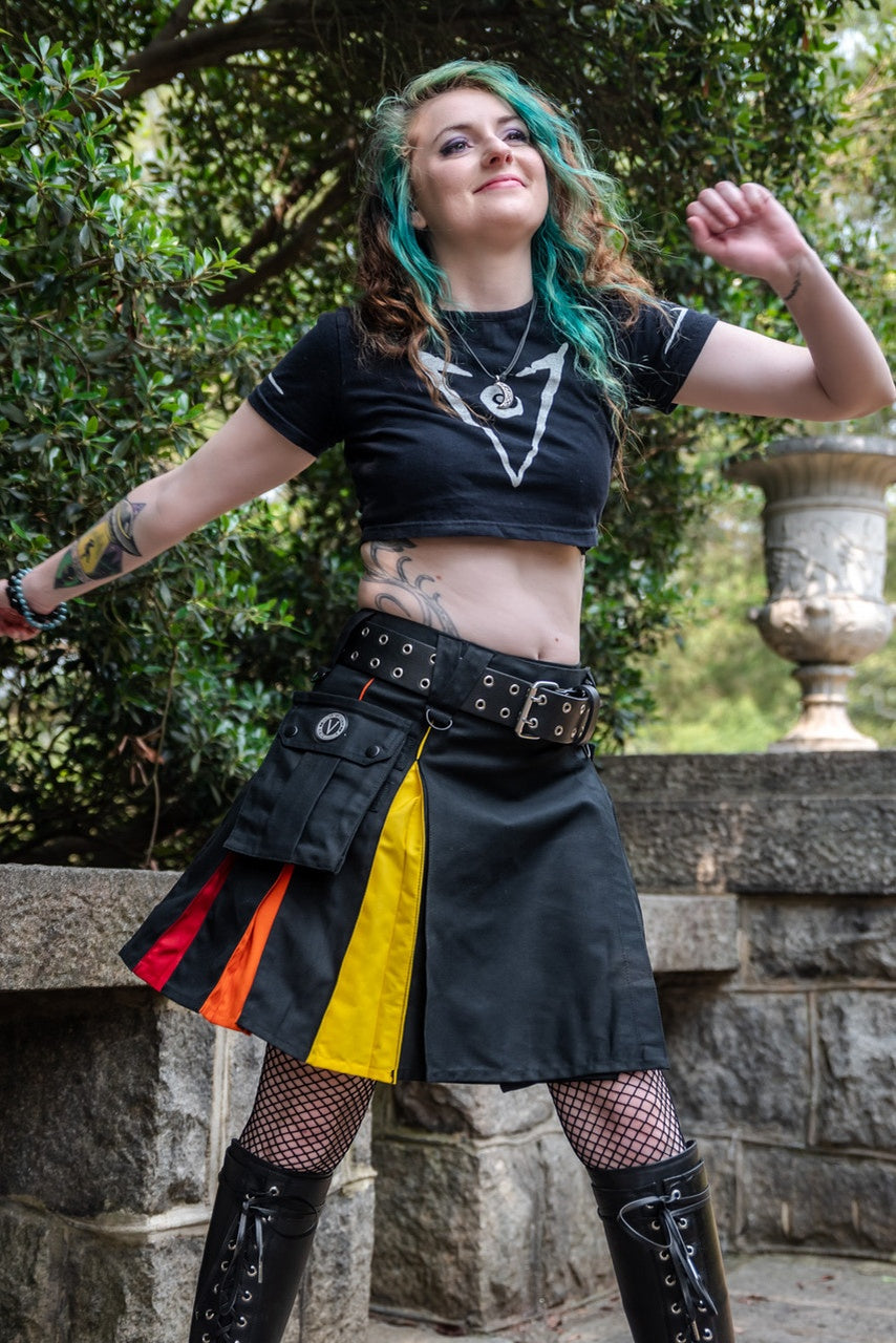 Person wearing a knee-length black  kilt with rainbow pleats in an outdoor setting