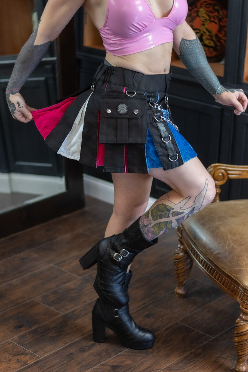 Person wearing a pink top, black kilt with red accents, and black boots in an indoor setting.