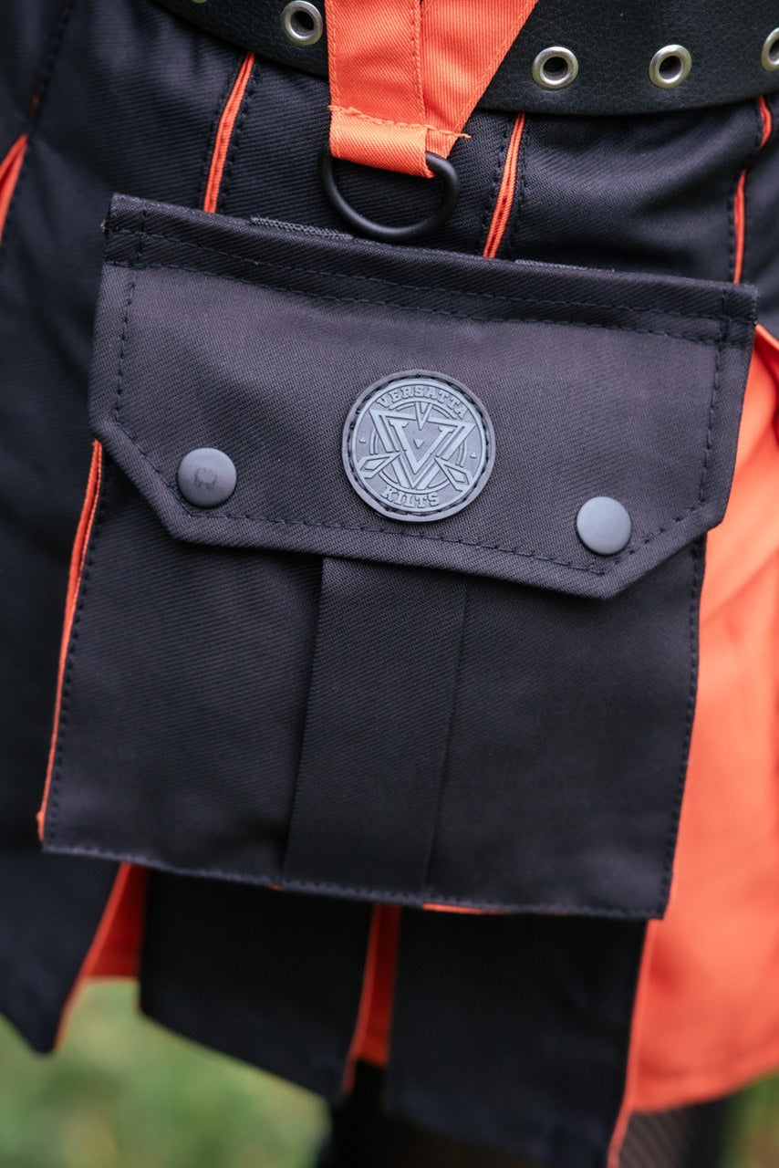 Close up image of the side pocket detail on a black and orange Versatta kilt