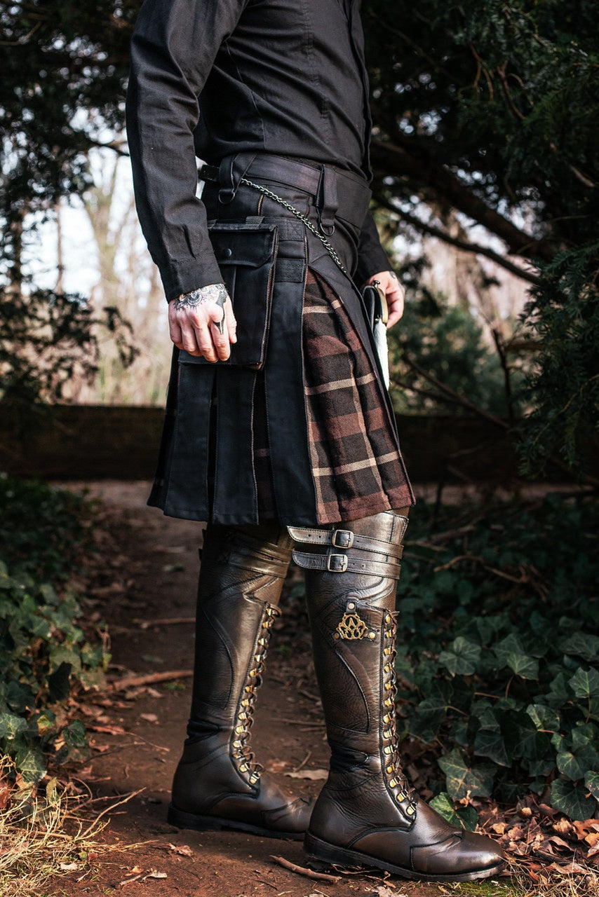 Person wearing a kilt and high boots in a forest setting