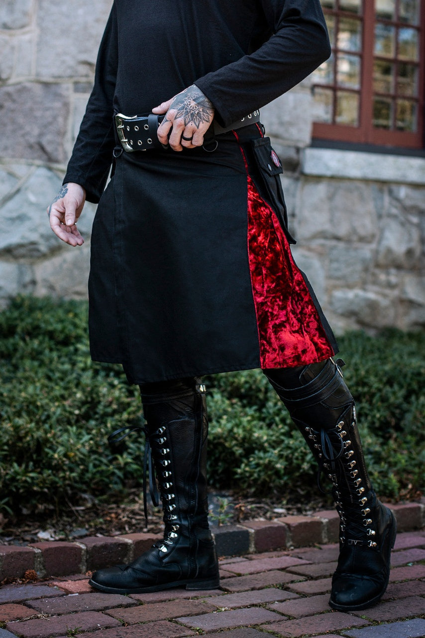 Person wearing a black and red outfit with high boots on a stone pathway.