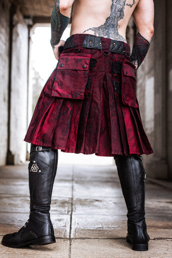 Person wearing a red kilt with black accents in an industrial setting