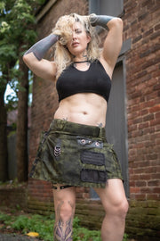 Woman wearing a black top and army green mini kilt with black accents.